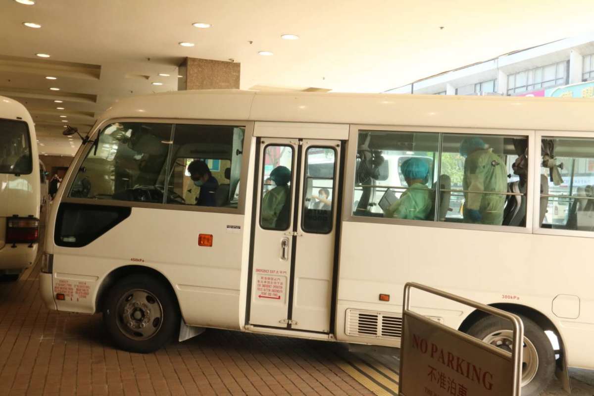 衞生署安排3輛中型旅遊巴，接載酒店員工去往檢疫中心。（點新聞記者攝）