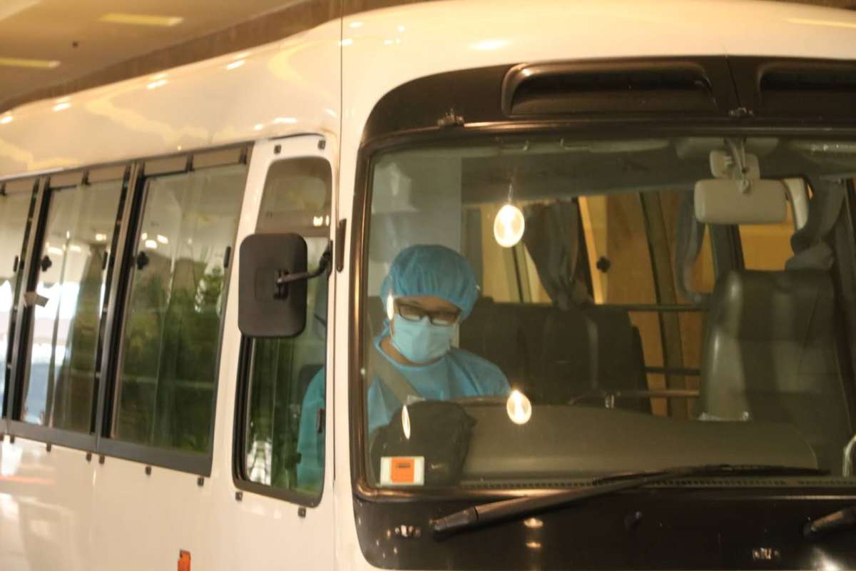 衞生署安排3輛中型旅遊巴，接載酒店員工去往檢疫中心。（點新聞記者攝）