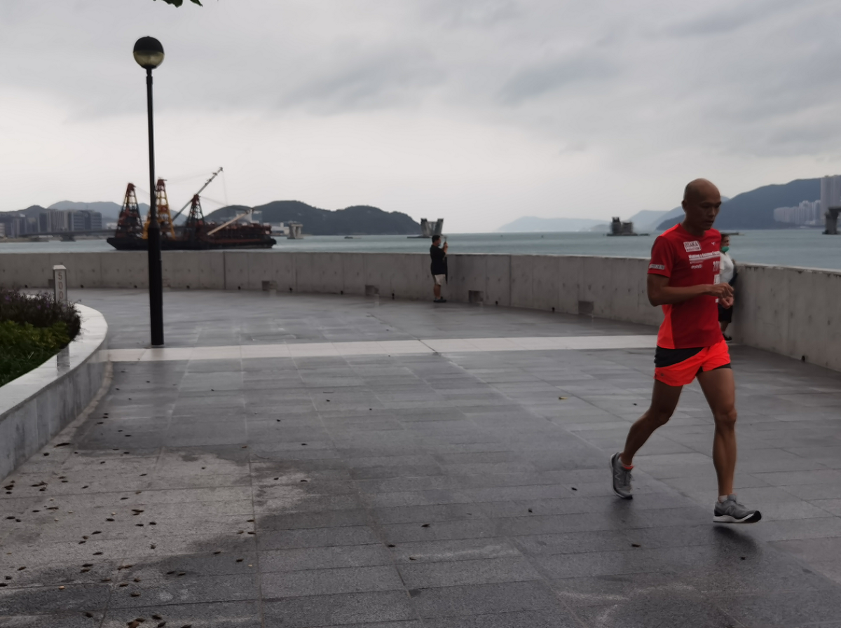 八號風球下，市民在將軍澳海濱跑步。（點新聞記者何燊亮攝）
