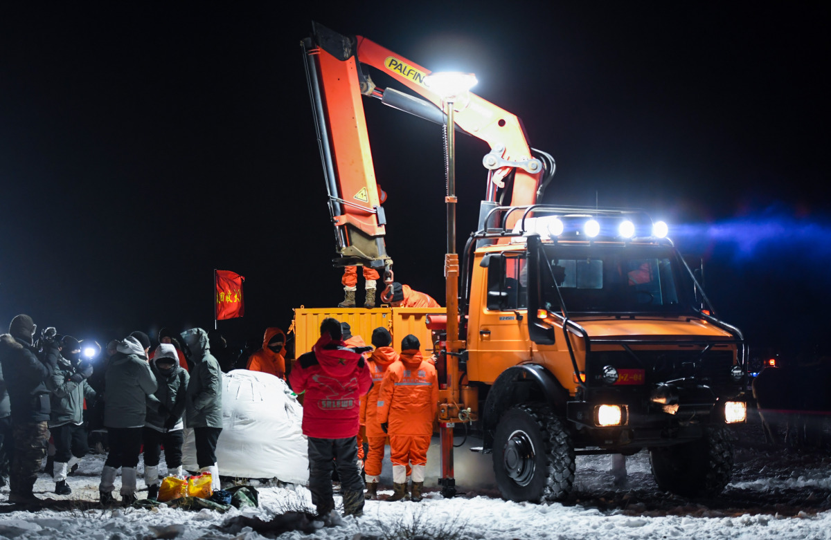 工作人員對返回器作包裹處理。（新華社）