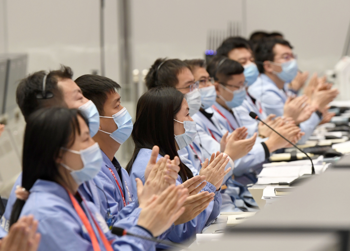 北京航天飛行控制中心工作人員鼓掌慶祝任務圓滿成功。（新華社）