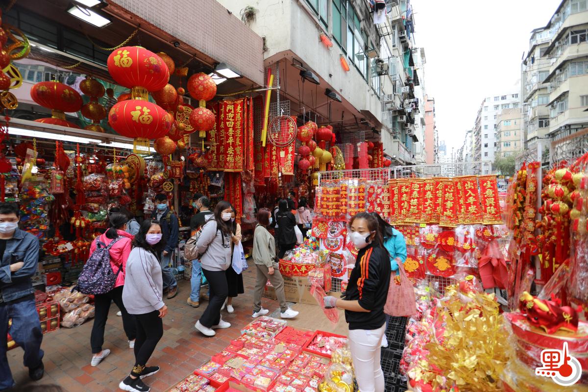 不少店鋪在路邊開檔賣牛年賀年公仔、特色揮春，利是封等，大半條街都一片紅噹噹，充滿濃厚節日氣氛。（點新聞記者李斯哲攝）