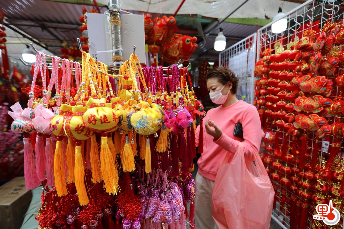 不少店鋪在路邊開檔賣牛年賀年公仔、特色揮春，利是封等，大半條街都一片紅噹噹，充滿濃厚節日氣氛。（點新聞記者李斯哲攝）