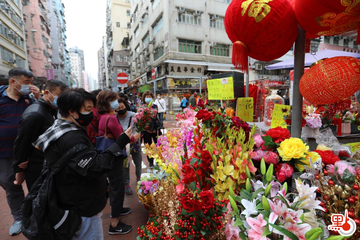 不少店鋪在路邊開檔賣牛年賀年公仔、特色揮春，利是封等，大半條街都一片紅噹噹，充滿濃厚節日氣氛。（點新聞記者李斯哲攝）