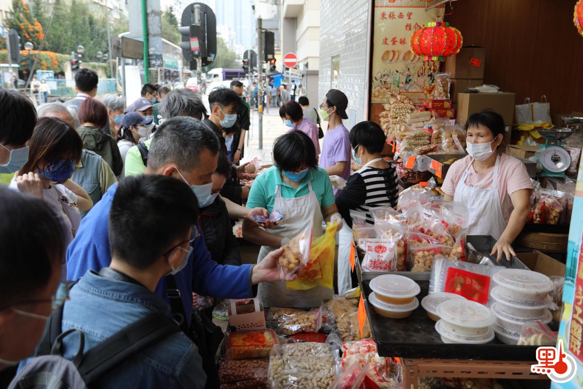 不少店鋪在路邊開檔賣牛年賀年公仔、特色揮春，利是封等，大半條街都一片紅噹噹，充滿濃厚節日氣氛。（點新聞記者李斯哲攝）