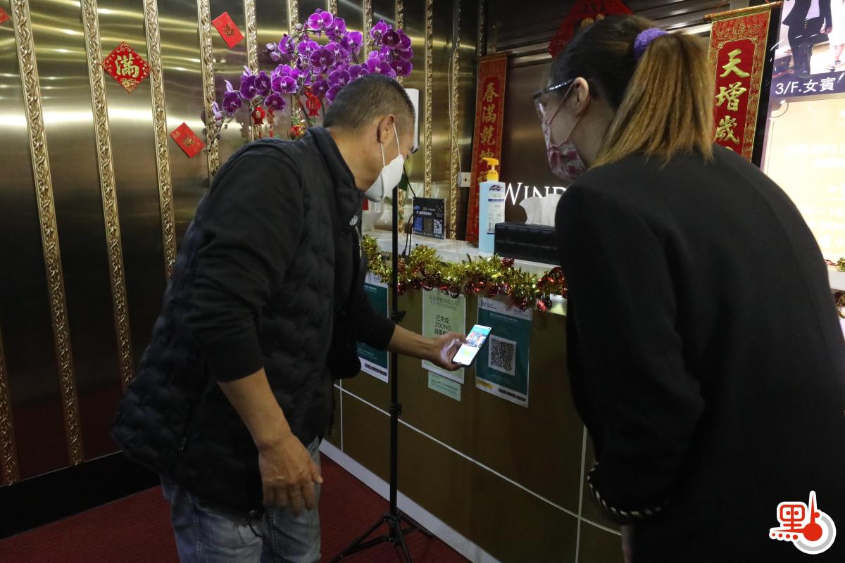 政府今日（18日）起放寬各項防疫措施，包括晚市堂食可延至晚上10時、每枱可坐4人；而限聚令亦可放寬至4人。多個處所都可以重開，包括體育場所、博物館、主題公園、遊樂場地等。圖為社交距離措施放寬後，Spa會所重新開業，市民掃描「安心出行」應用程式後，才可以進入。（點新聞記者攝）