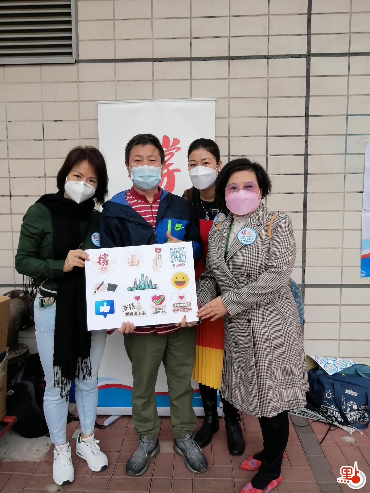 香港河南總商會理事長高波，香港河南總商會青年委員會主席、沙田圍社區窩心服務隊隊長郭宣彤一同在沙田圍地鐵站宣傳人大完善香港選舉制度的決定，呼籲市民簽名支持。（受訪者供圖）