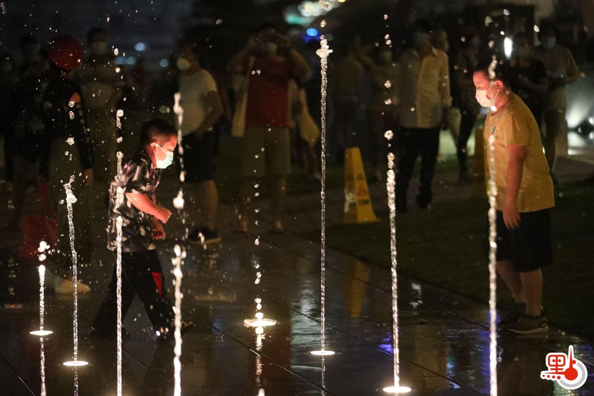 許多小童興奮與噴泉互動，穿梭水柱間嬉戲。（點新聞記者萬靈霜攝）