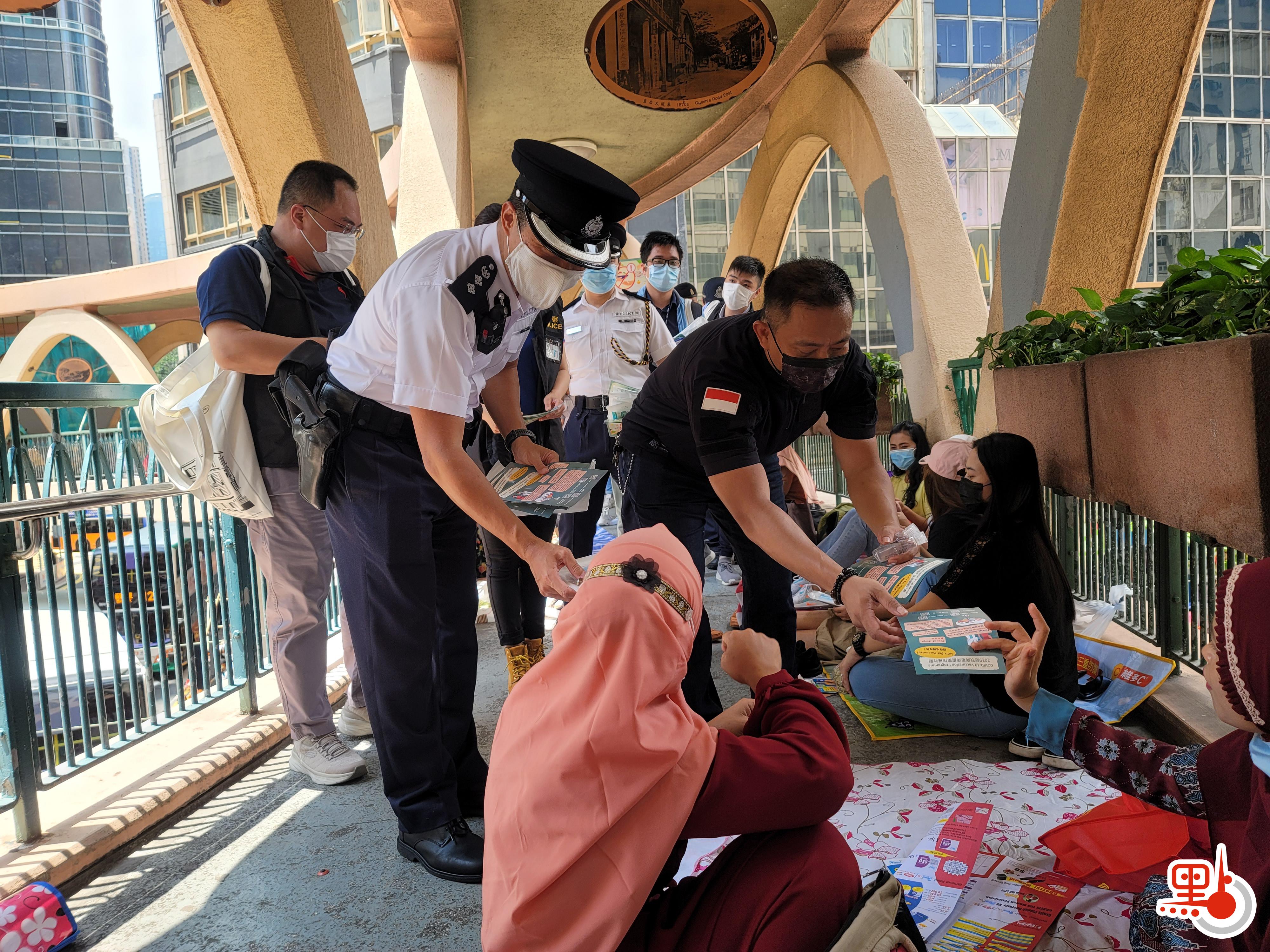 灣仔警區指揮官陳思達及印尼駐港領事館人員到銅鑼灣鬧市向外傭派發防疫口罩、搓手液及防疫宣傳單張，呼籲遵守防疫措施。（點新聞記者 何燊亮攝）