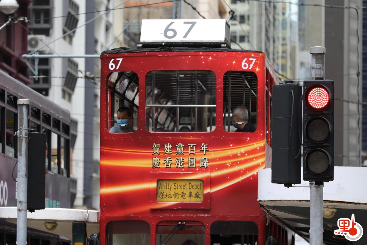 香港街頭現紅色巴士電車，喜迎建黨百年，慶香港回歸。有電車車身噴繪7月1日可邀請乘客免費乘車。（點新聞記者李斯哲攝）