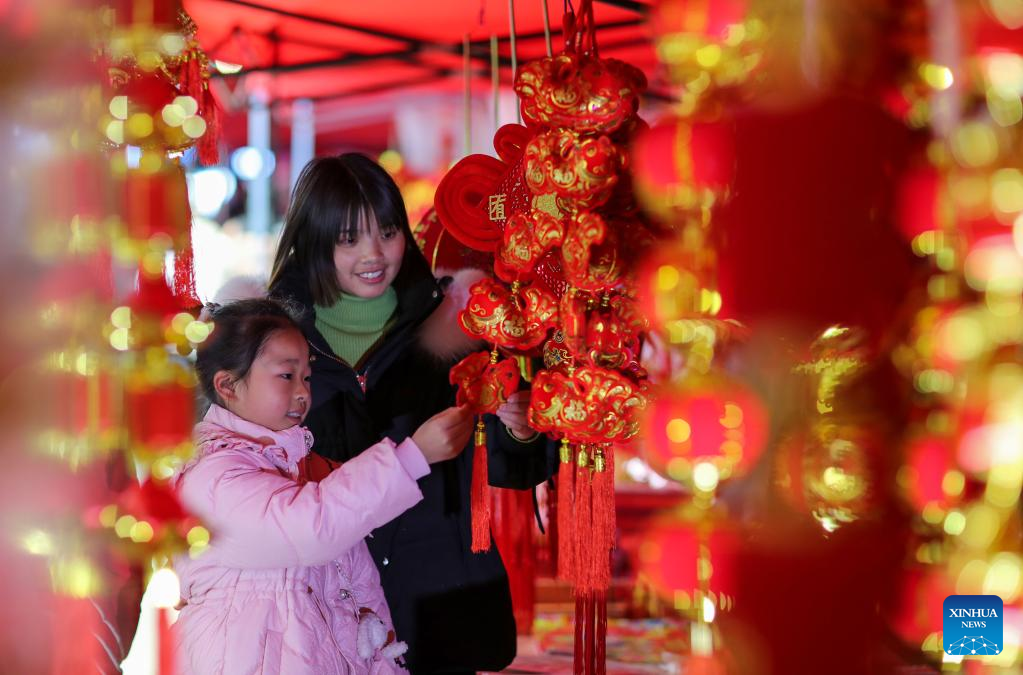 People select festive decorations ahead of the Spring Festival in Cengong County of Qiandongnan Miao and Dong Autonomous Prefecture, southwest China's Guizhou Province, Jan. 17, 2023. This year's Spring Festival, or the Chinese New Year, falls on Jan. 22. (Photo by Hu Panxue/Xinhua)