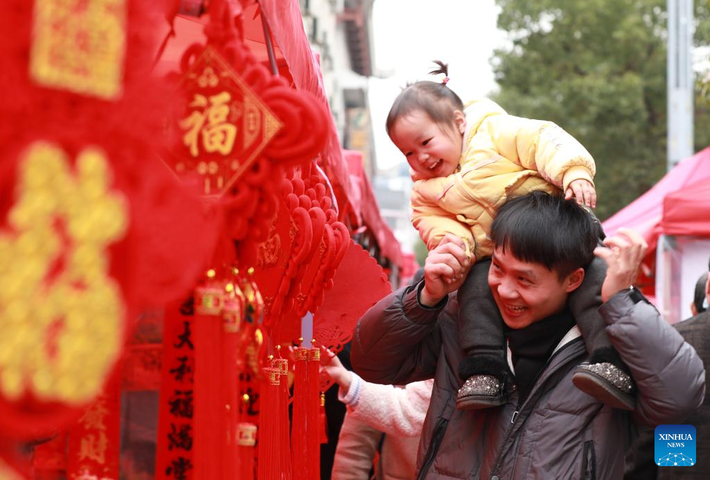 People buy festive decorations ahead of the Spring Festival in Jianhe County of Qiandongnan Miao and Dong Autonomous Prefecture, southwest China's Guizhou Province, Jan. 18, 2023. This year's Spring Festival, or the Chinese New Year, falls on Jan. 22. (Photo by Wan Wenjie/Xinhua)