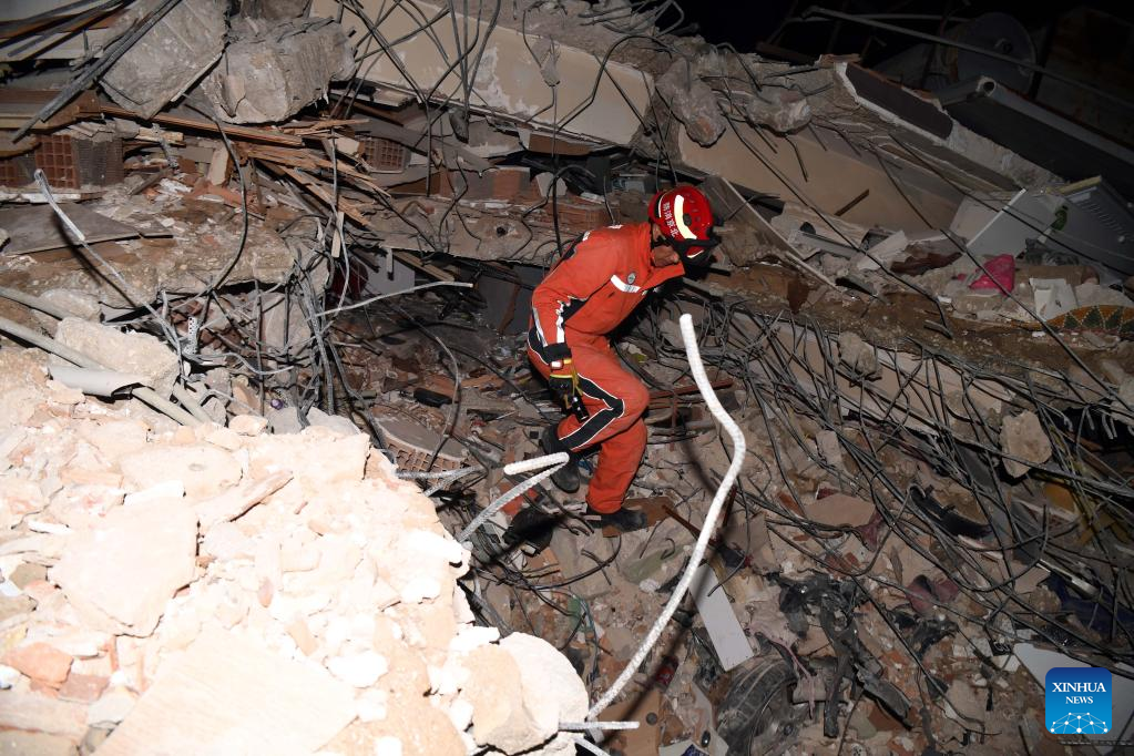 A member of the China Search and Rescue Team interacts with a rescue dog at a stadium in the southern province of Hatay, Trkiye, Feb. 8, 2023. (Xinhua/Shadati)