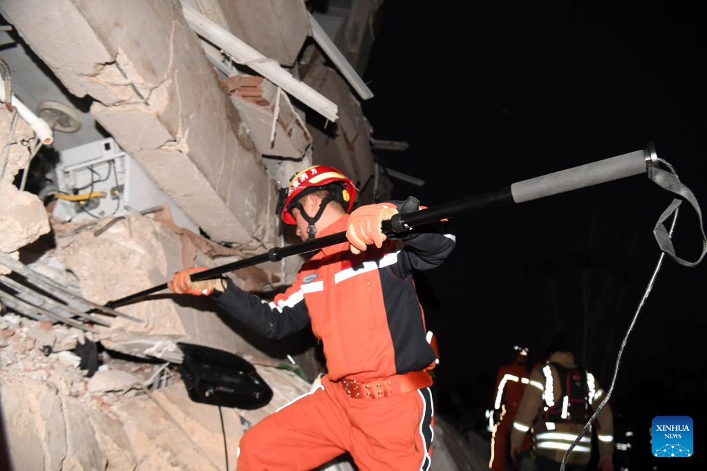 A member of the China Search and Rescue Team interacts with a rescue dog at a stadium in the southern province of Hatay, Trkiye, Feb. 8, 2023. (Xinhua/Shadati)