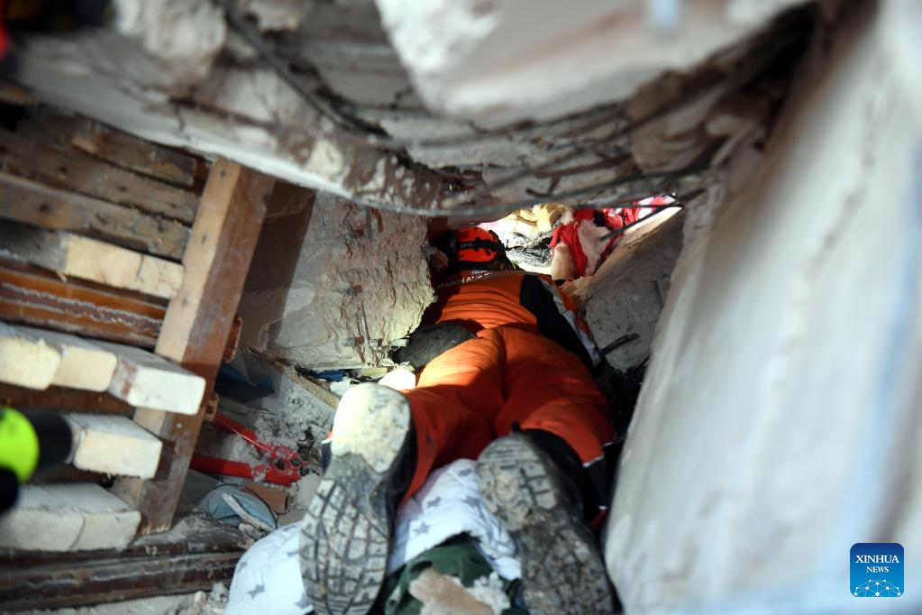 A member of the China Search and Rescue Team interacts with a rescue dog at a stadium in the southern province of Hatay, Trkiye, Feb. 8, 2023. (Xinhua/Shadati)
