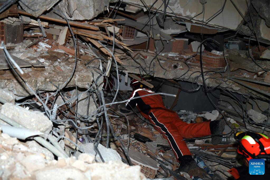 A member of the China Search and Rescue Team interacts with a rescue dog at a stadium in the southern province of Hatay, Trkiye, Feb. 8, 2023. (Xinhua/Shadati)