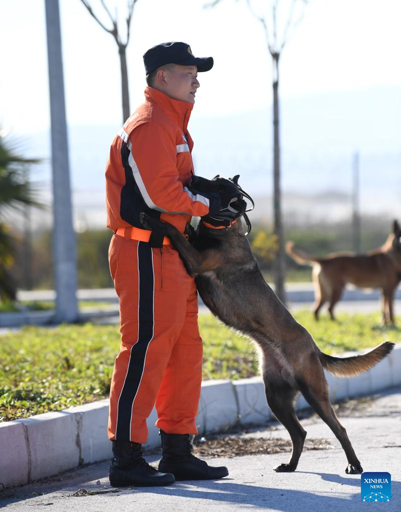 A member of the China Search and Rescue Team interacts with a rescue dog at a stadium in the southern province of Hatay, Trkiye, Feb. 8, 2023. (Xinhua/Shadati)