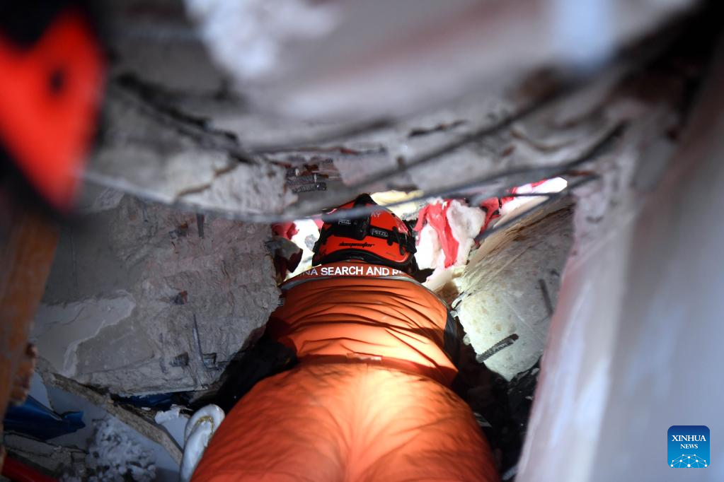 A member of the China Search and Rescue Team interacts with a rescue dog at a stadium in the southern province of Hatay, Trkiye, Feb. 8, 2023. (Xinhua/Shadati)