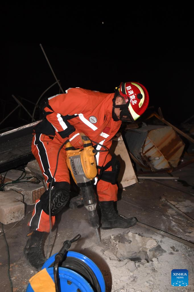 A member of the China Search and Rescue Team interacts with a rescue dog at a stadium in the southern province of Hatay, Trkiye, Feb. 8, 2023. (Xinhua/Shadati)
