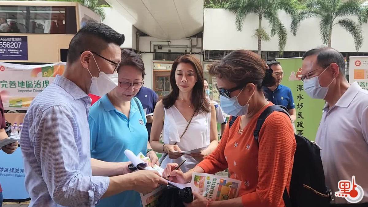 石硤尾地鐵站出口，深水埗民政事務專員黃昕然(左)正收集市民的簽名。(受訪者提供)