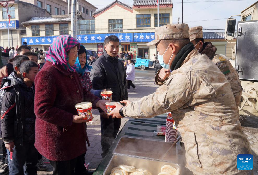 Soldiers provide hot food for quake-affected people in Liuji Township, Jishishan County, northwest China's Gansu Province, Dec. 21, 2023. The Chinese People's Liberation Army (PLA) and the People's Armed Police Force (PAPF) have deployed multiple rescue forces to quake-hit areas in response to a 6.2-magnitude earthquake that jolted northwest China's Gansu Province late Monday. (Xinhua/Zhang Yongjin)