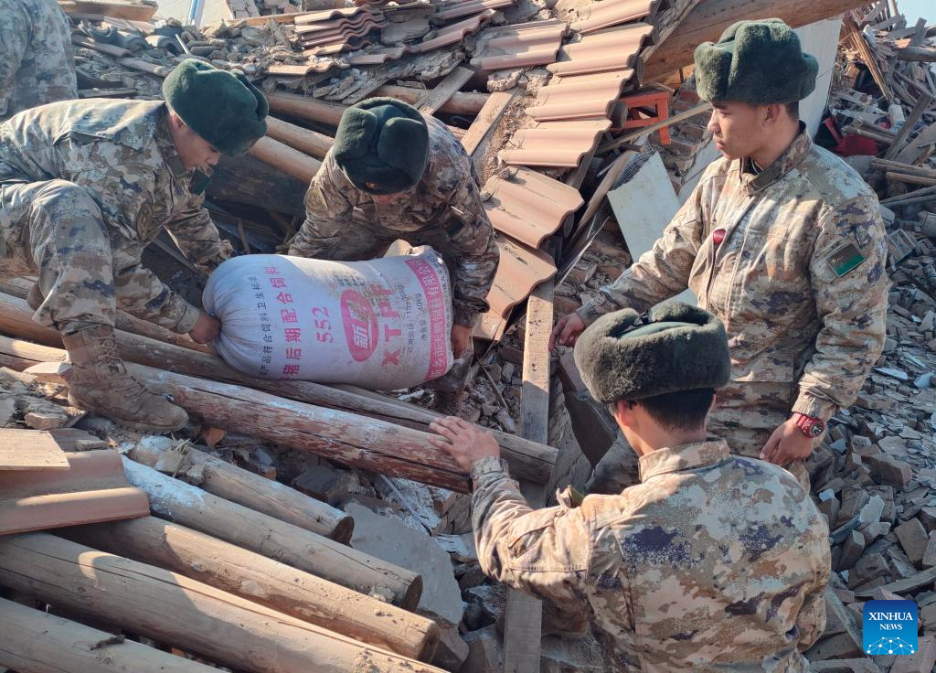 Soldiers help to clear materials for quake-affected people in Shiyuan Township, Jishishan County, northwest China's Gansu Province, Dec. 21, 2023. The Chinese People's Liberation Army (PLA) and the People's Armed Police Force (PAPF) have deployed multiple rescue forces to quake-hit areas in response to a 6.2-magnitude earthquake that jolted northwest China's Gansu Province late Monday. (Photo by Bai Jiacheng/Xinhua)
