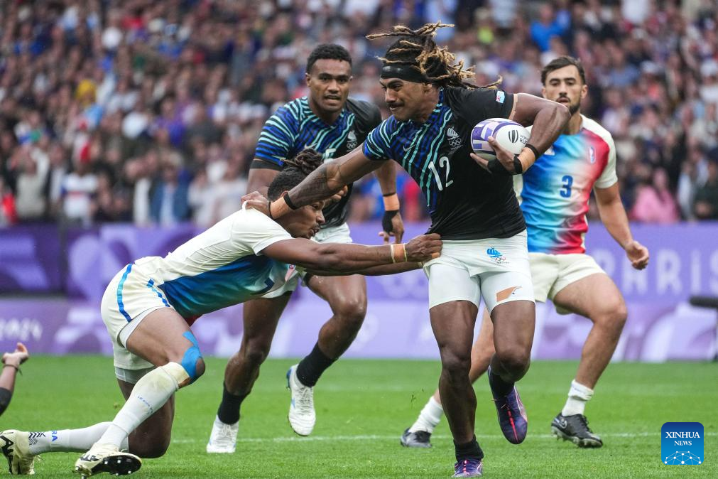 Selesitino Ravutaumada (2nd R) of Team Fiji launches an attack during the rugby sevens men's gold medal match between France and Fiji at the Paris 2024 Olympic Games in Paris, France, July 27, 2024. France won 28-7 and secured the gold medal. (Xinhua/Xu Chang)