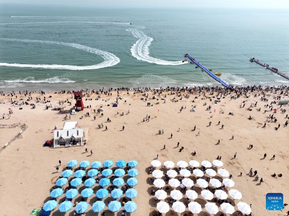 An aerial drone photo taken on April 5, 2026 shows tourists enjoying leisure activities on a beach during the Qingming Festival holiday in Lianyungang City, east China's Jiangsu Province. (Xinhua)