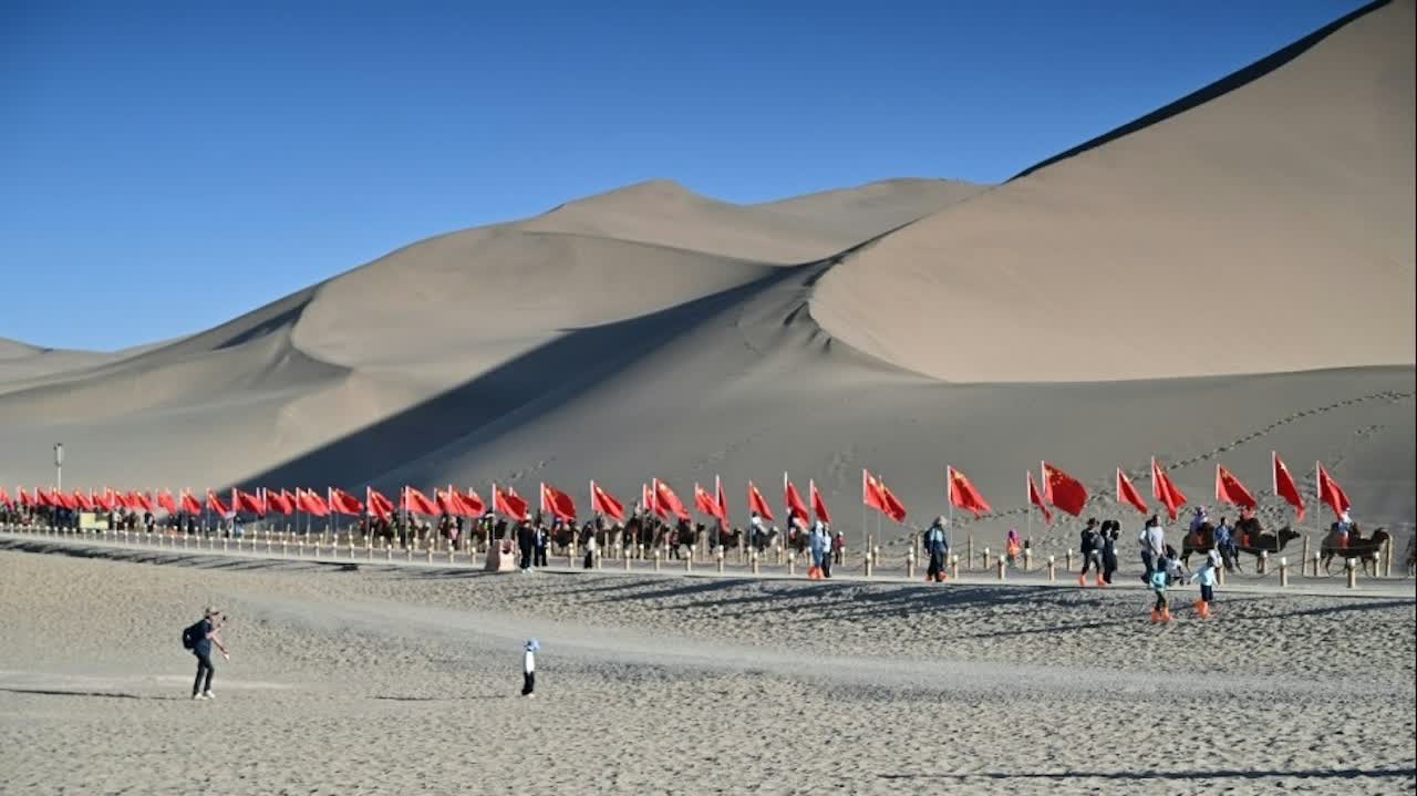 National Day travel boom: Crowds pack Dunhuang's Mingsha Mountain in festive, orderly scenes