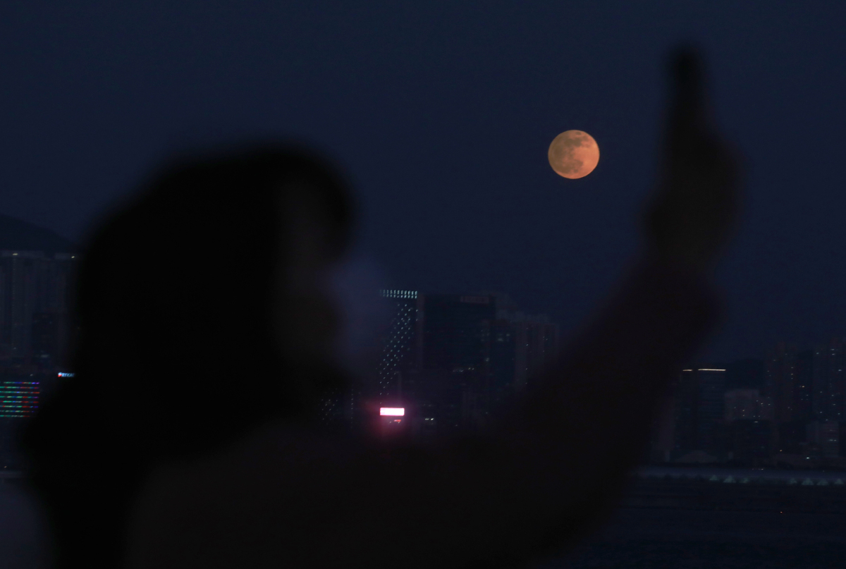 今日（30日）黃昏時分，香港出現今年第三次、亦是最後一次「半影月食」現象。圖為市民遠眺月食景象。（點新聞記者攝）